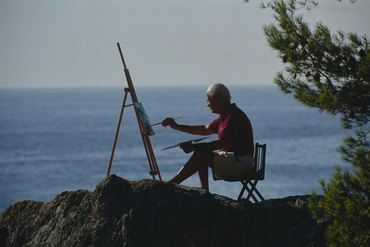 Artista pintant al costat del mar
