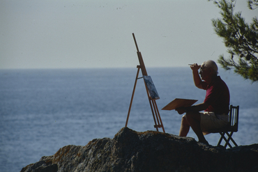 Artista pintant al costat del mar