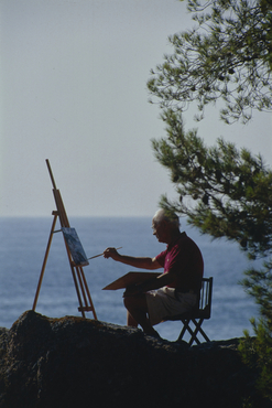 Artista pintant al costat del mar