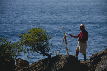 Artista pintant al costat del mar