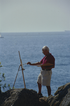 Artista pintant al costat del mar