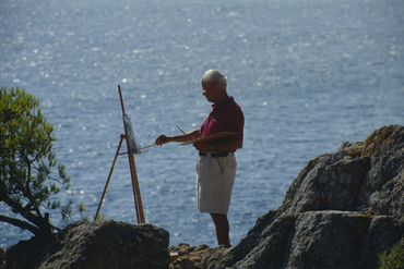 Artista pintant al costat del mar
