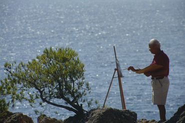Artista pintant al costat del mar