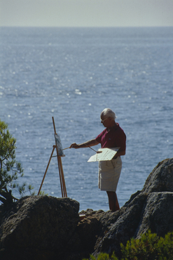 Artista pintant al costat del mar