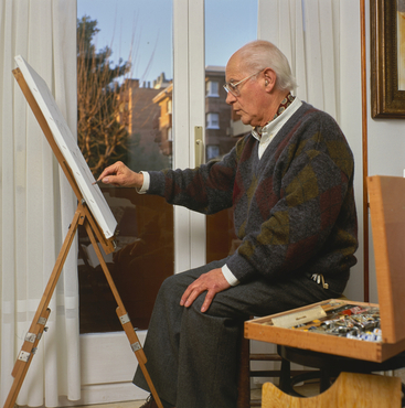 Artista pintant a l'interior de casa