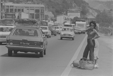 Noies fent autoestop davant una cua de cotxes a la carretera N-II en direcció cap a França
