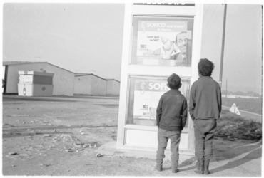 Dos nens davant d'una cabina telefònica als albergs provisionals de Domeny