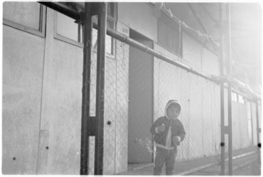 Una criatura al porxo d'un dels albergs provisionals de Domeny