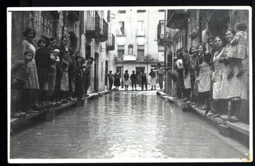 Inundació de Banyoles a causa del desbordament de l'estany. Carrer Major inundat, amb habitants