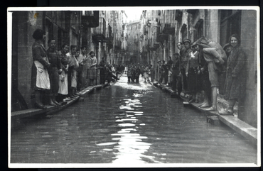 Inundació de Banyoles a causa del desbordament de l'estany. Carrer Major inundat, amb habitants