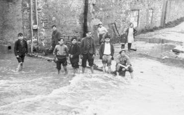 Inundació de Banyoles a causa del desbordament de l'estany. Carrer inundat, amb habitants