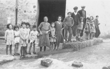 Inundació de Banyoles a causa del desbordament de l'estany. Habitants davant d'un portal d'un carrer inundat