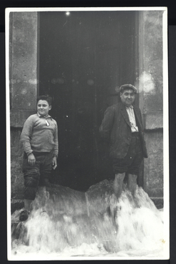 Inundació de Banyoles a causa del desbordament de l'estany. Home i noi davant del museu Darder