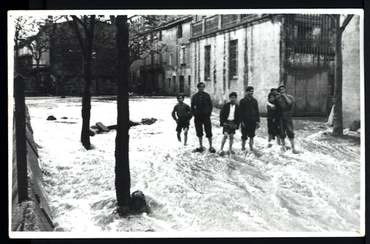 Inundació de Banyoles a causa del desbordament de l'estany. Plaça del Monestir inundada, amb habitants