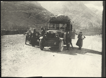 Carretera amb cotxes antics i conductors parats al centre 