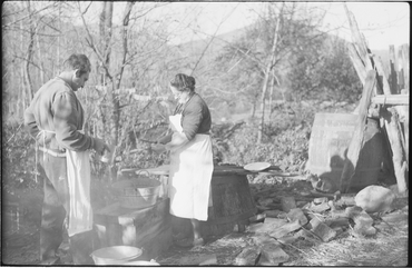 Home i dona cuinant als boscos de Beget